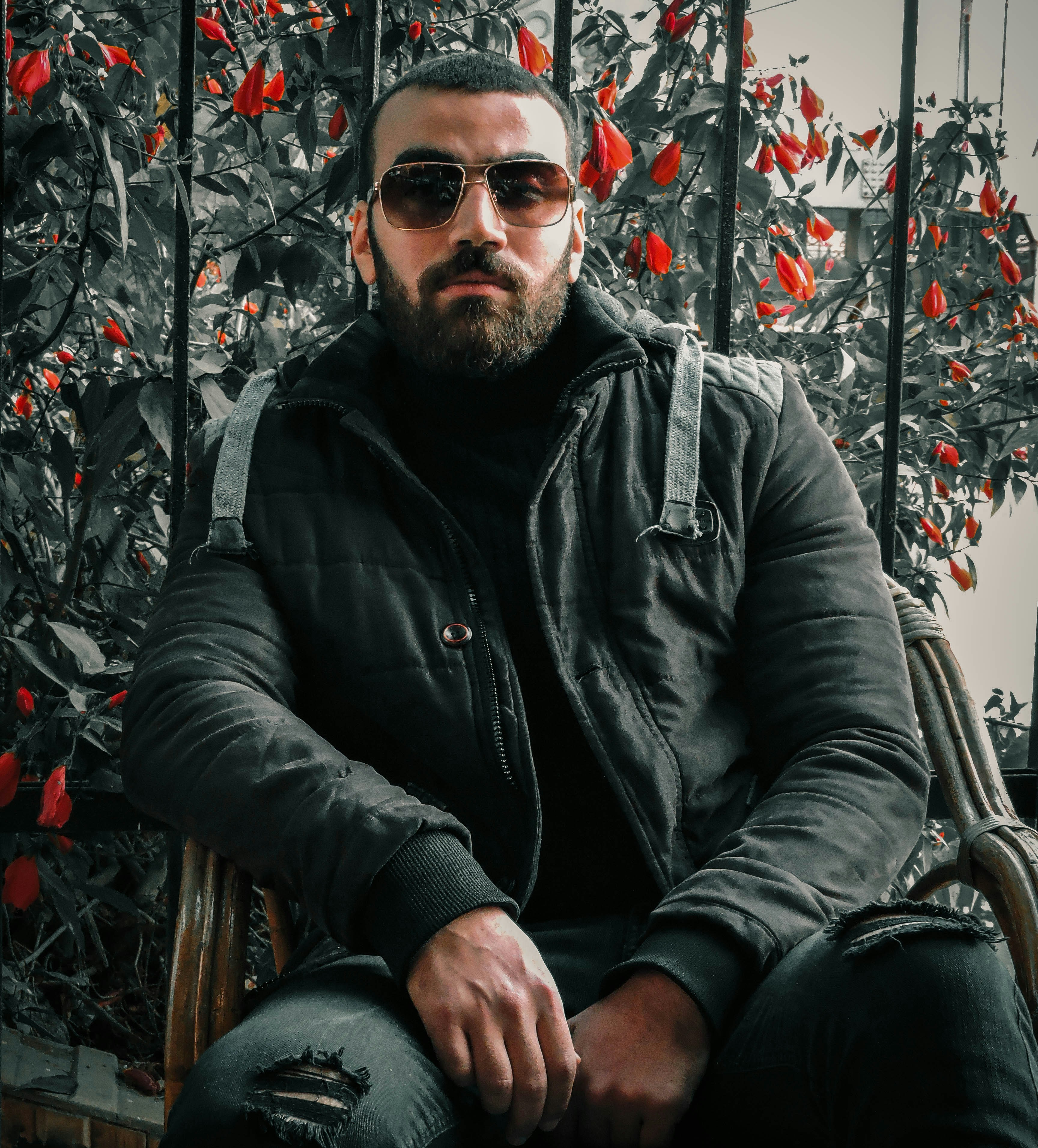 man in black leather jacket and black sunglasses sitting on chair